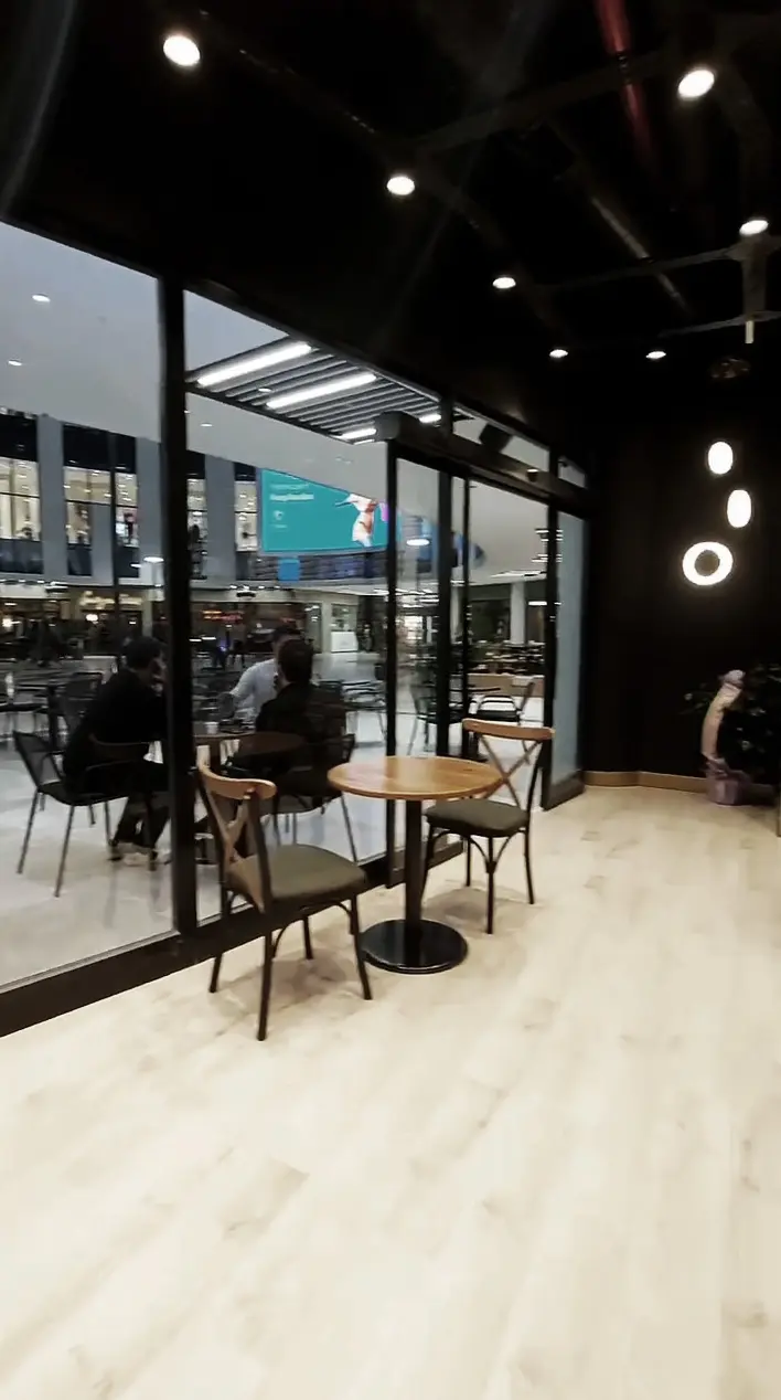 Seating area along the glazed front with round tables