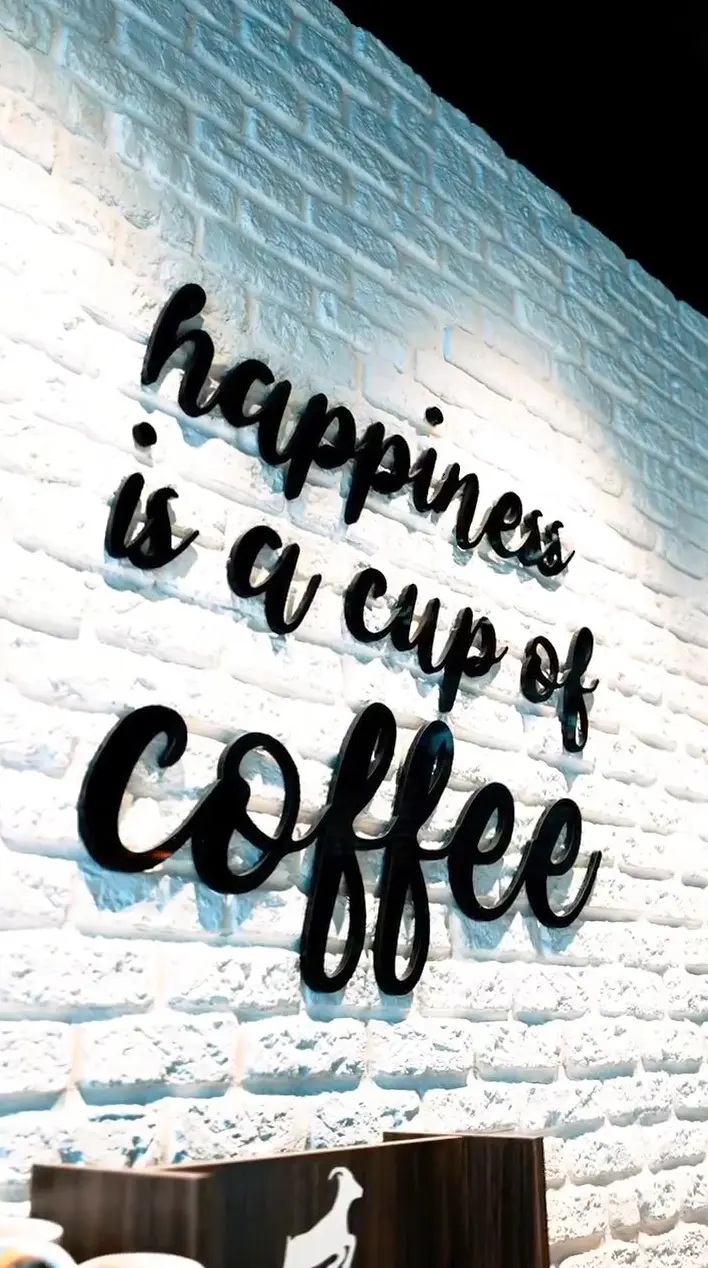 Black script lettering on the white brick wall