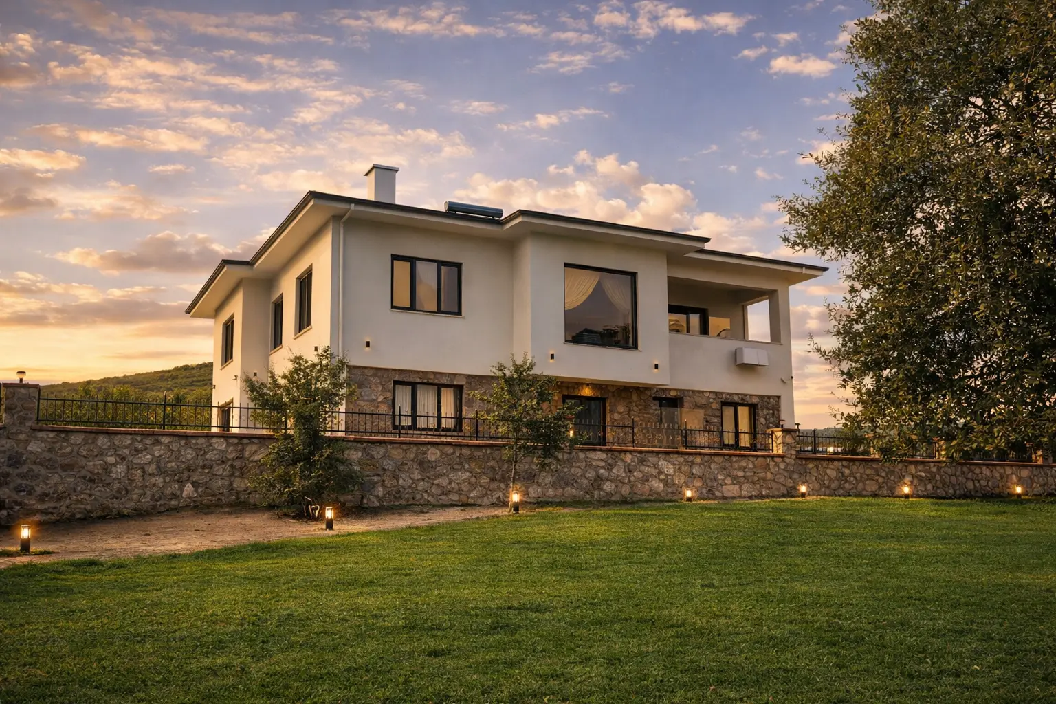 Gün batımında taş bahçe duvarı ve beyaz sıvalı ev, SS Mountain House, Sinop.