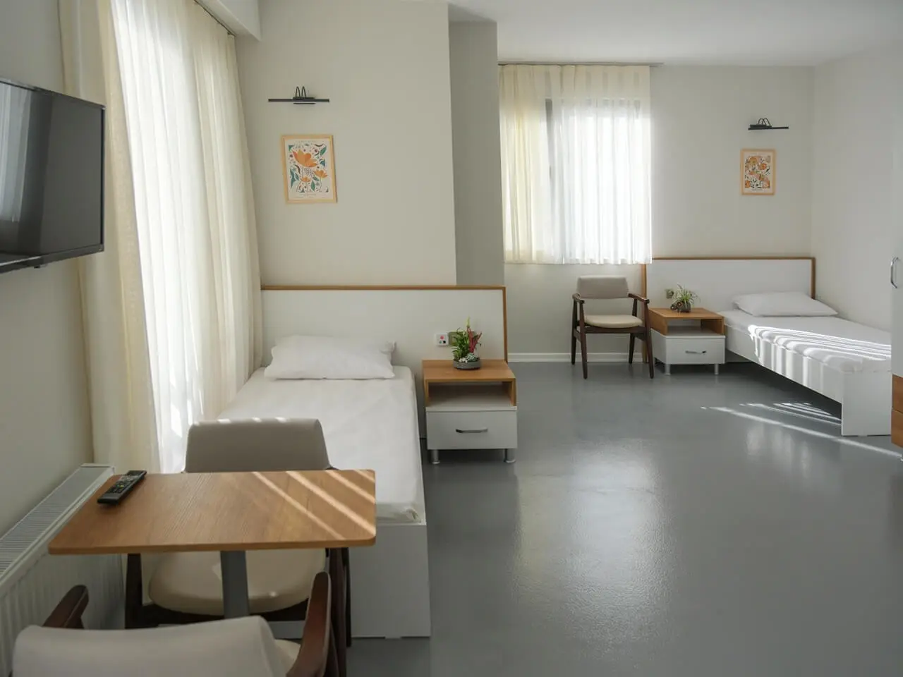 Twin room with bedside units and a table by the window.